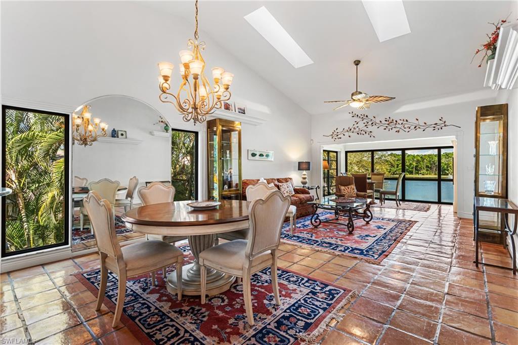 Great room features vaulted ceiling, skylights, and to-floor windows