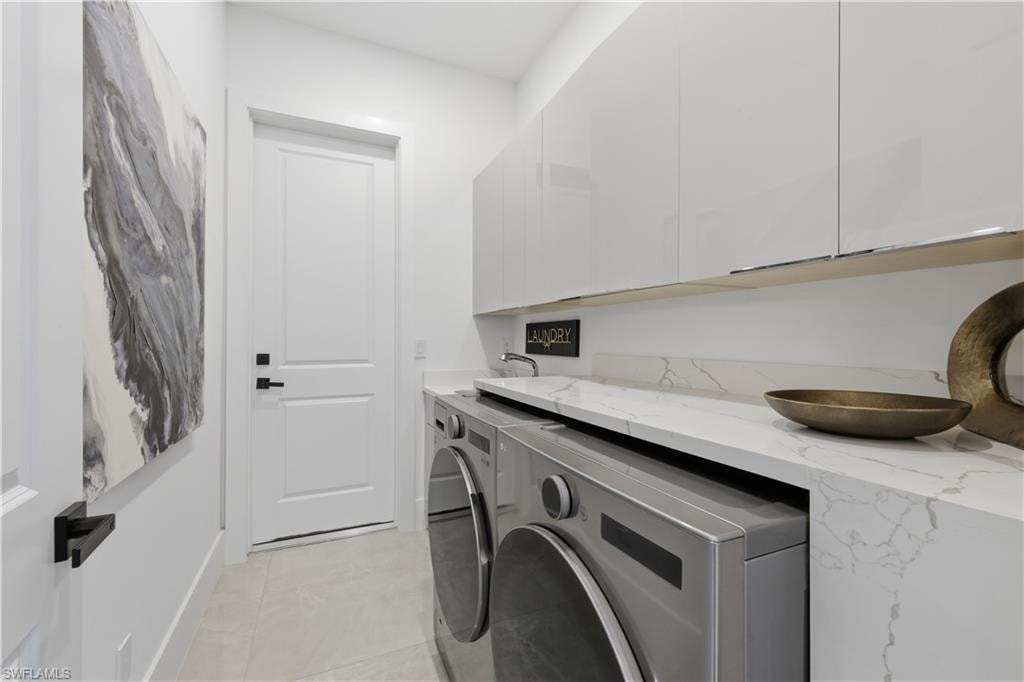 Laundry room featuring cabinet space and washer and clothes dryer