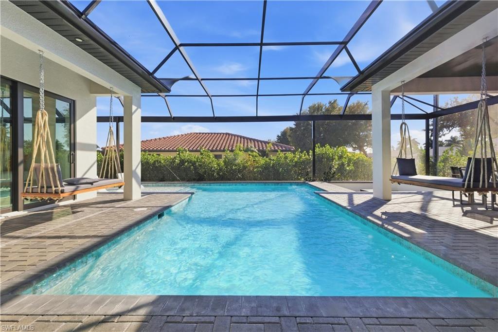 Outdoor pool featuring a sunroom, a patio, and a lanai