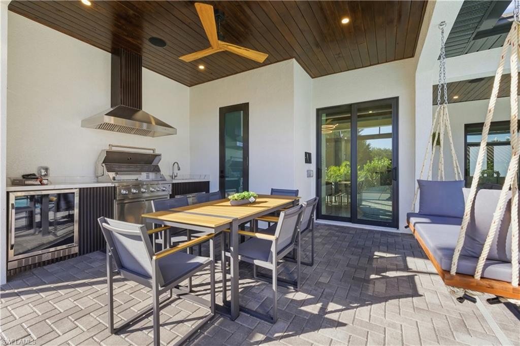 View of patio / terrace featuring an outdoor kitchen / dining area, wine cooler, and ceiling fan