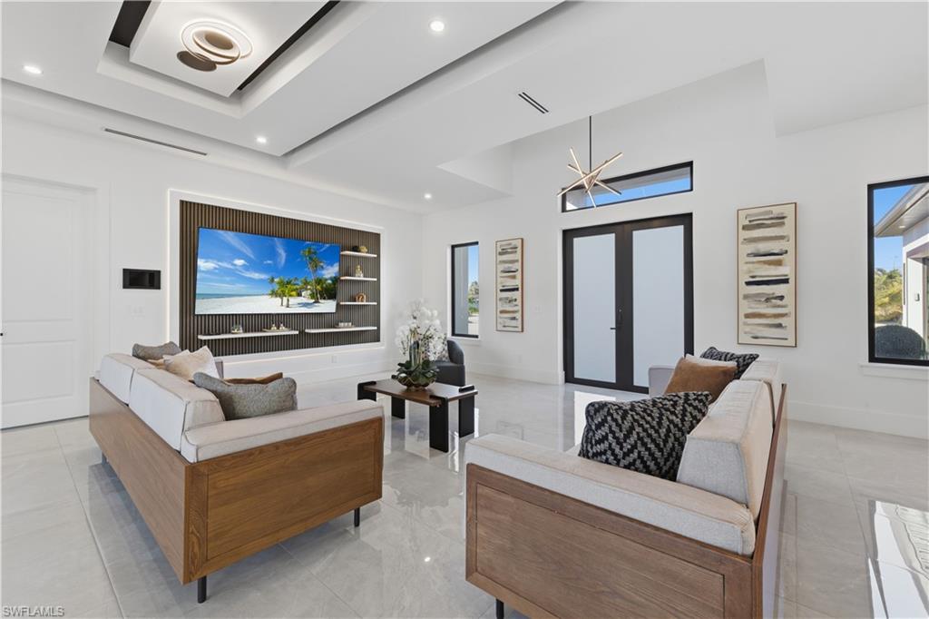 Living area with french doors, a high ceiling, and recessed lighting