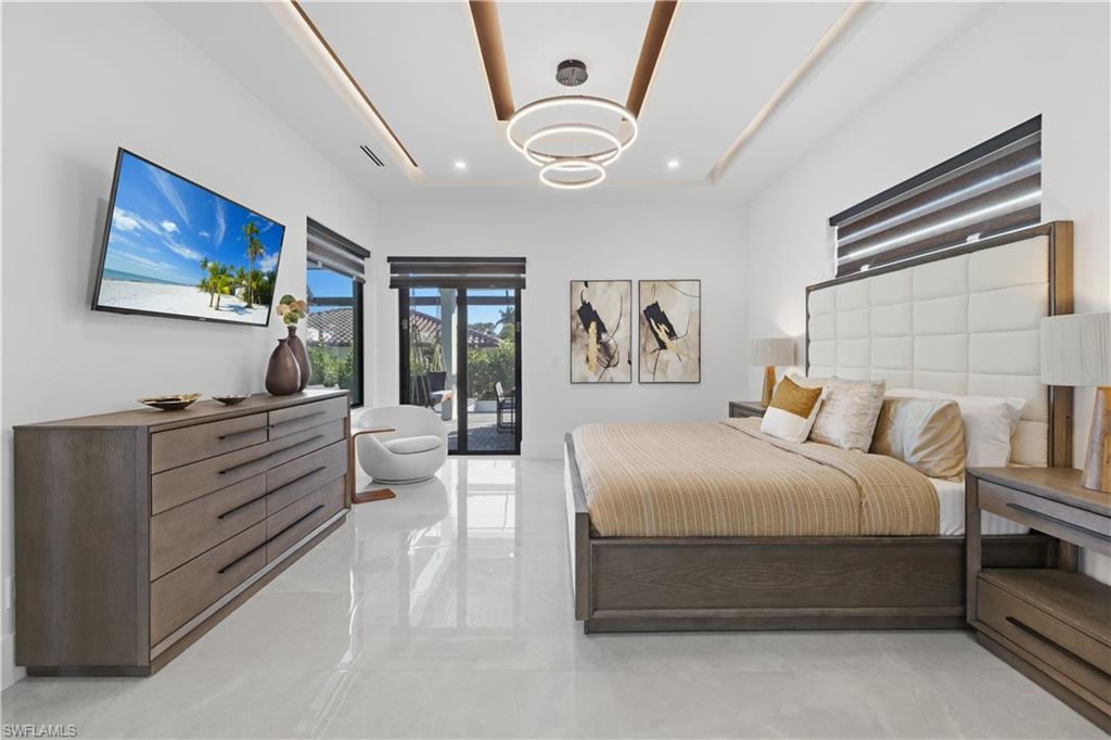 Bedroom with access to exterior and a raised ceiling