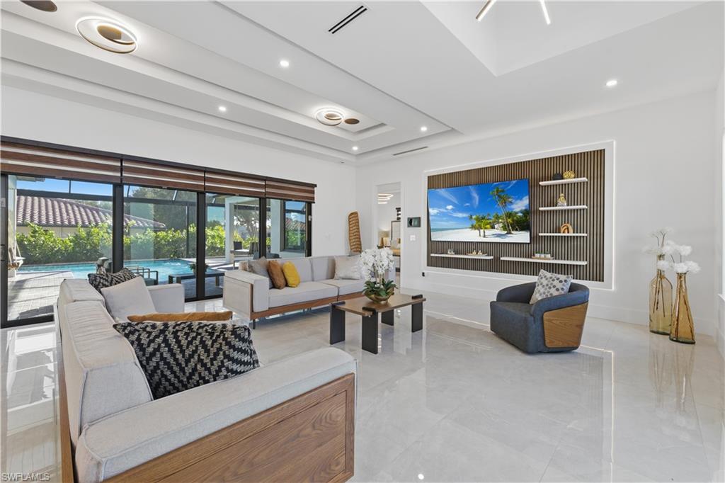 Living room featuring a tray ceiling and recessed lighting