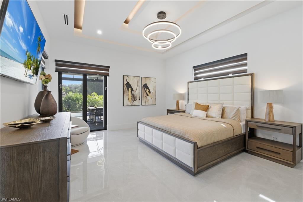 Bedroom with a raised ceiling and access to exterior