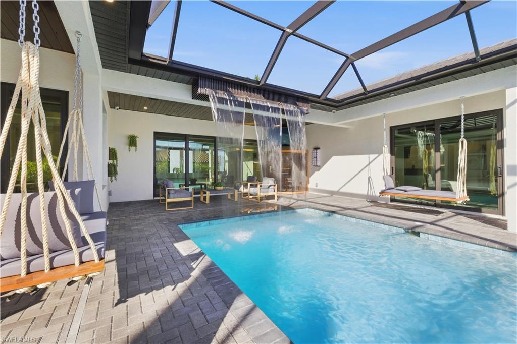 Swimming pool featuring a patio area, a sunroom, and a lanai