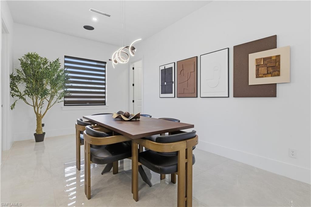 Dining area featuring baseboards and a chandelier