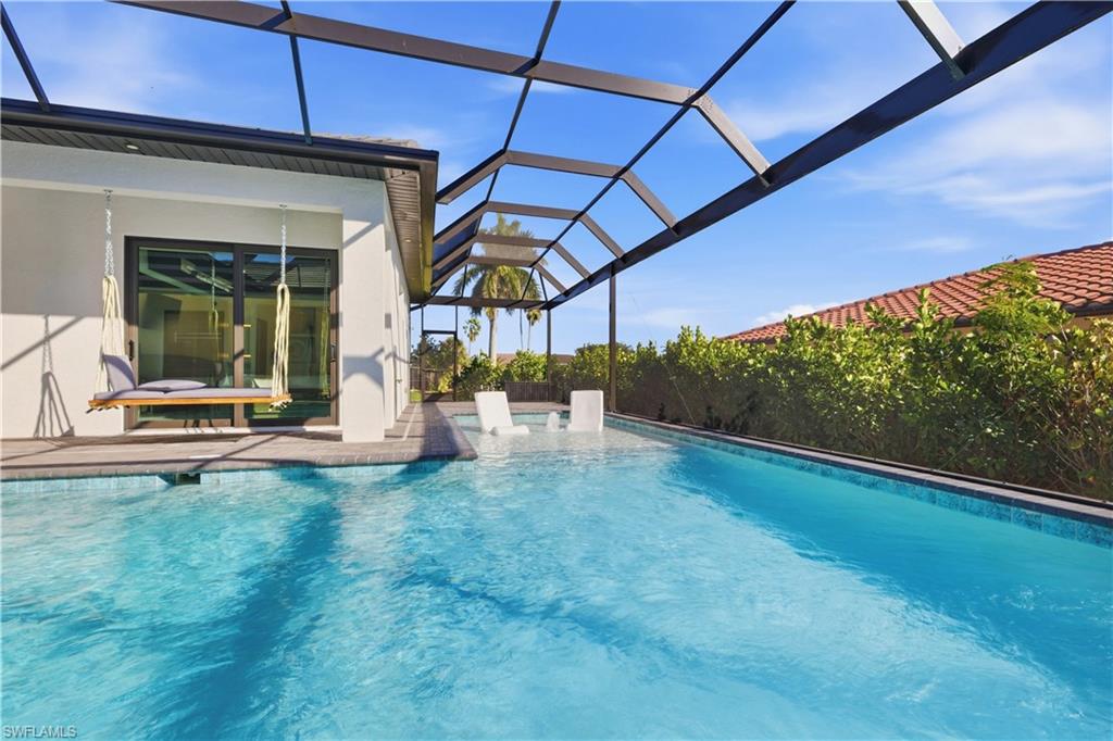 Swimming pool with glass enclosure, a sunroom, and a patio