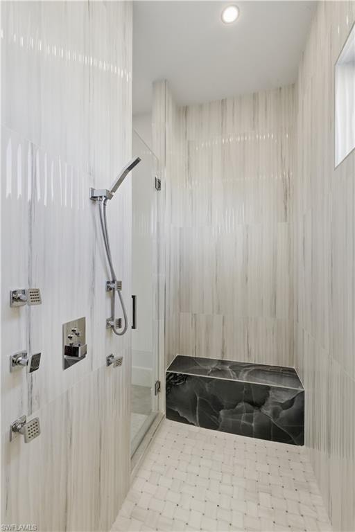 Full bath with a marble finish shower and recessed lighting