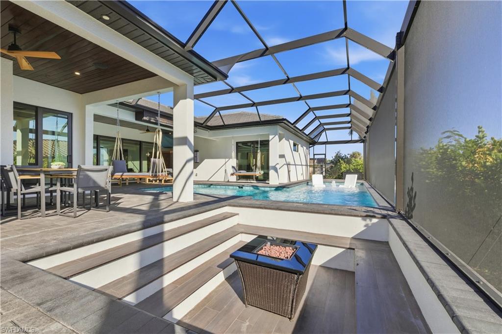 Outdoor pool featuring a patio, a sunroom, outdoor dining area, and a lanai