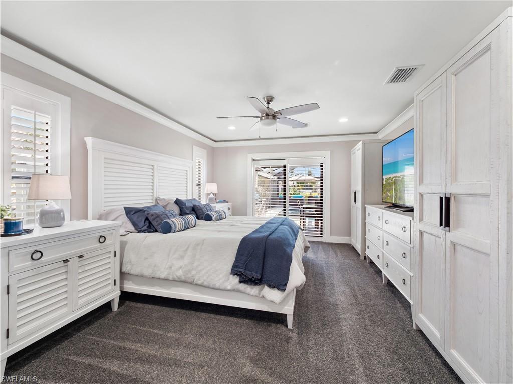Bedroom featuring dark colored carpet, a ceiling fan, ornamental molding, access to exterior, and recessed lighting