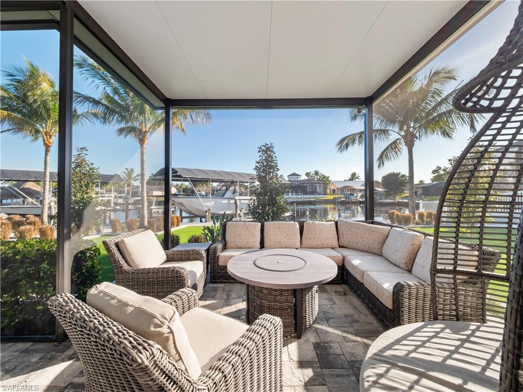 View of patio / terrace with a sunroom, an outdoor lounge area, a residential view, and a water view