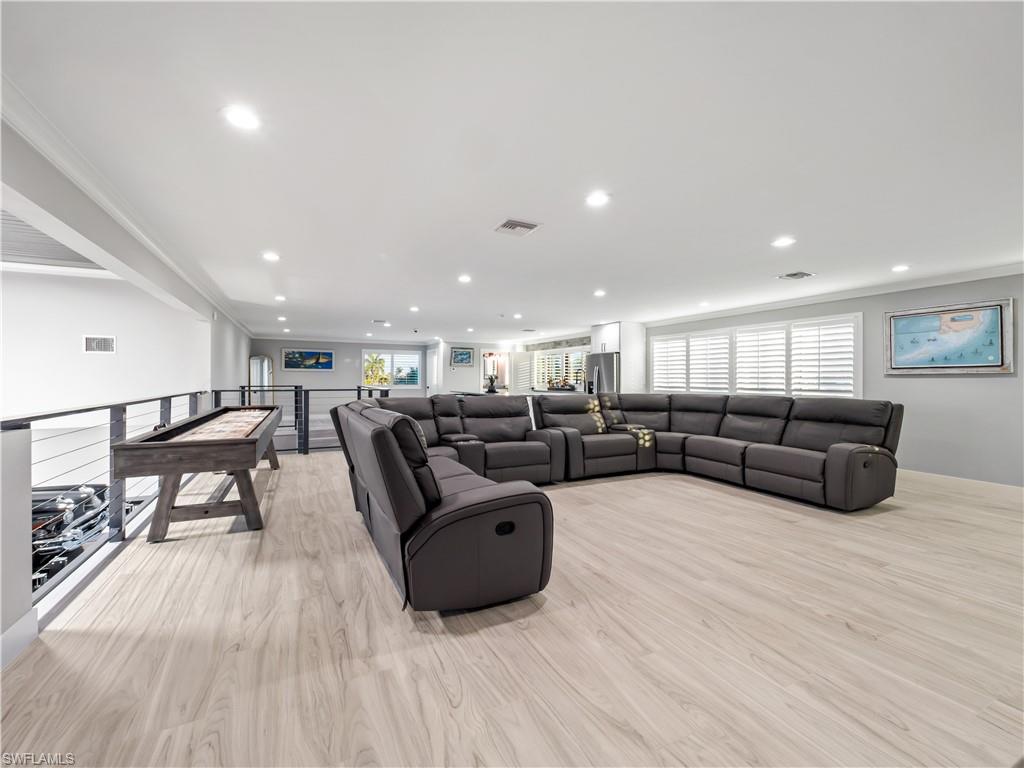 Living area with light wood-type flooring, crown molding, and recessed lighting