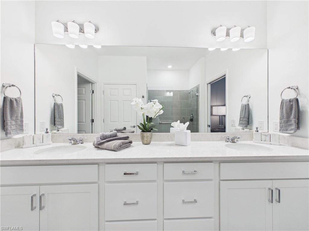 Full bath featuring double vanity and a shower stall