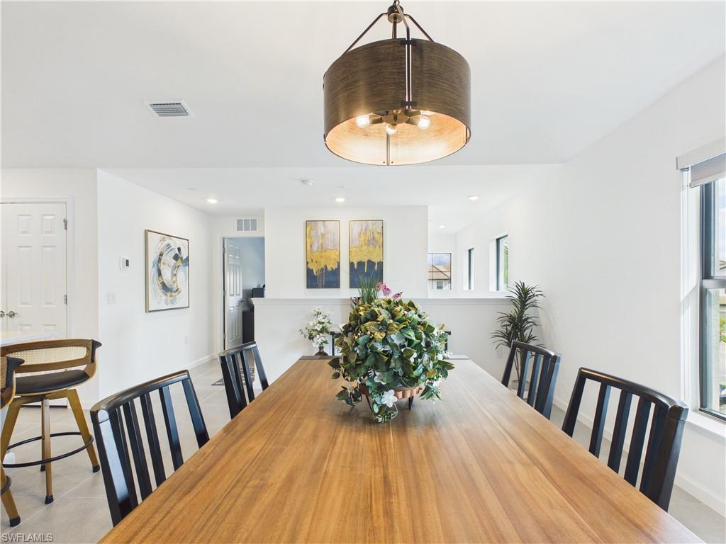 Dining area with light tile patterned flooring and recessed lighting