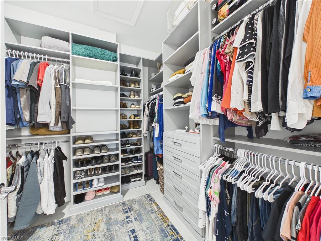 Walk in closet with attic access and light tile patterned floors