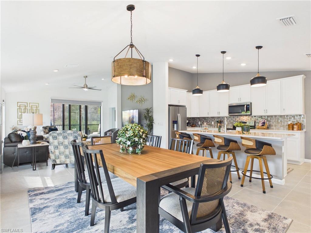 Dining space featuring ceiling fan, vaulted ceiling, light tile patterned floors, and recessed lighting
