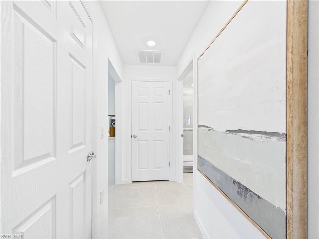 Corridor with light tile patterned floors and recessed lighting