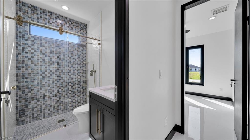 Full bathroom featuring vanity, a stall shower, and recessed lighting