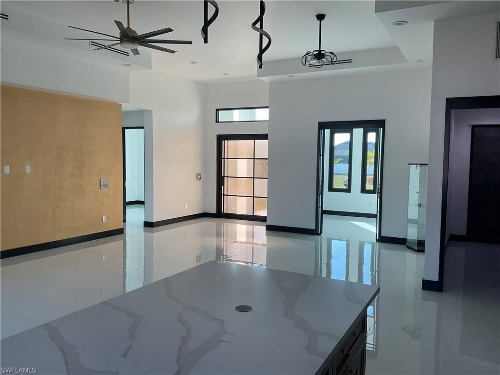 Spare room featuring a ceiling fan and a high ceiling
