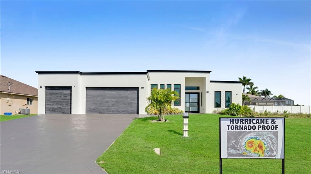 Contemporary home featuring a garage, driveway, and stucco siding
