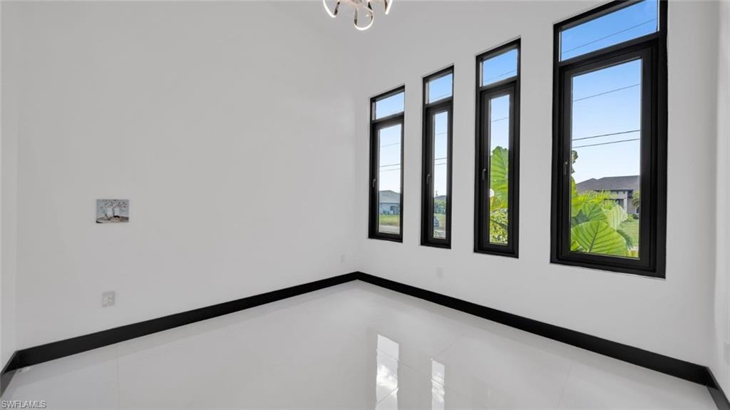 Spare room featuring baseboards and hanging lights