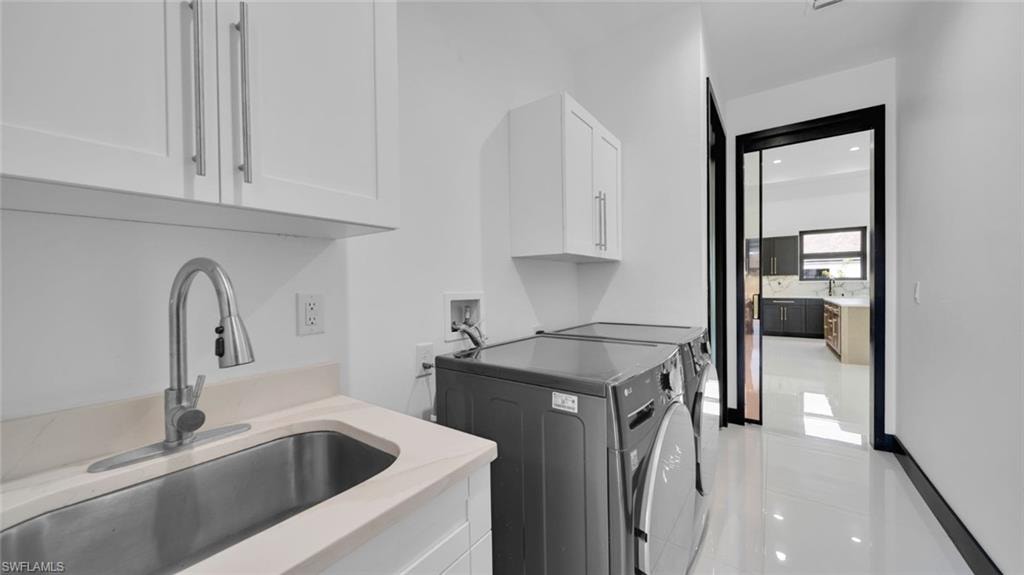 Laundry area with washing machine and dryer, cabinet space, recessed lighting, and light tile patterned floors