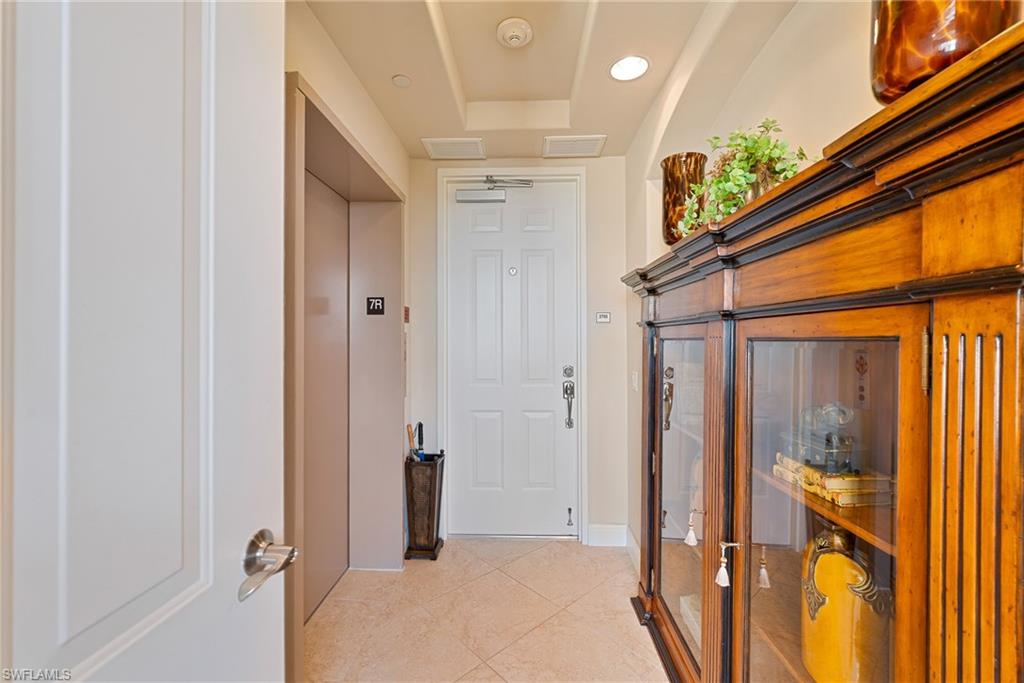 Private foyer with private elevator, light tile patterned floors, recessed lighting, and a raised ceiling