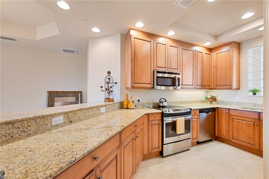 Kitchen with stainless steel appliances, light stone counters, recessed lighting, and light tile patterned floors