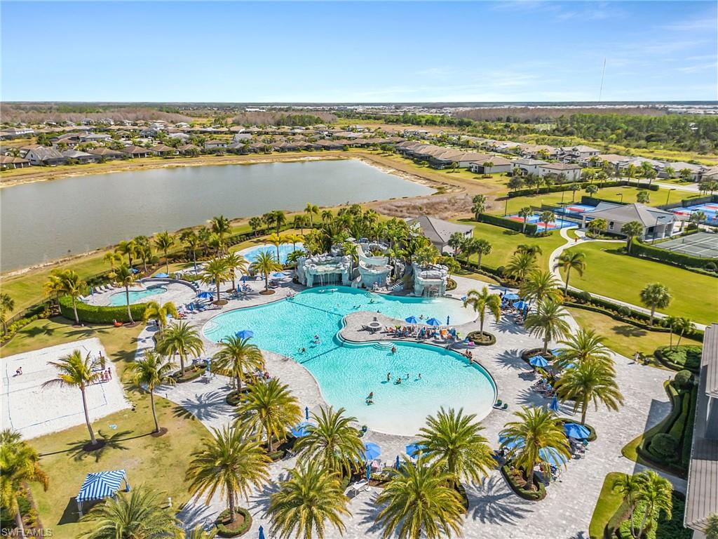 Aerial perspective of suburban area with a pool and a large body of water