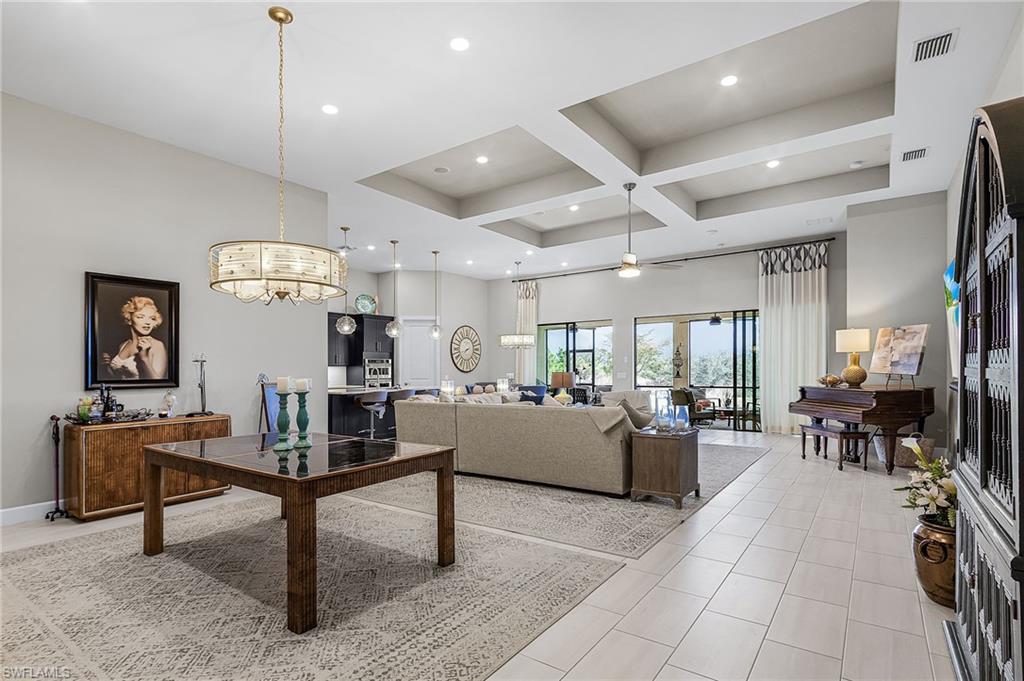 Living room with coffered ceiling, ceiling fan, recessed lighting, and light tile patterned flooring