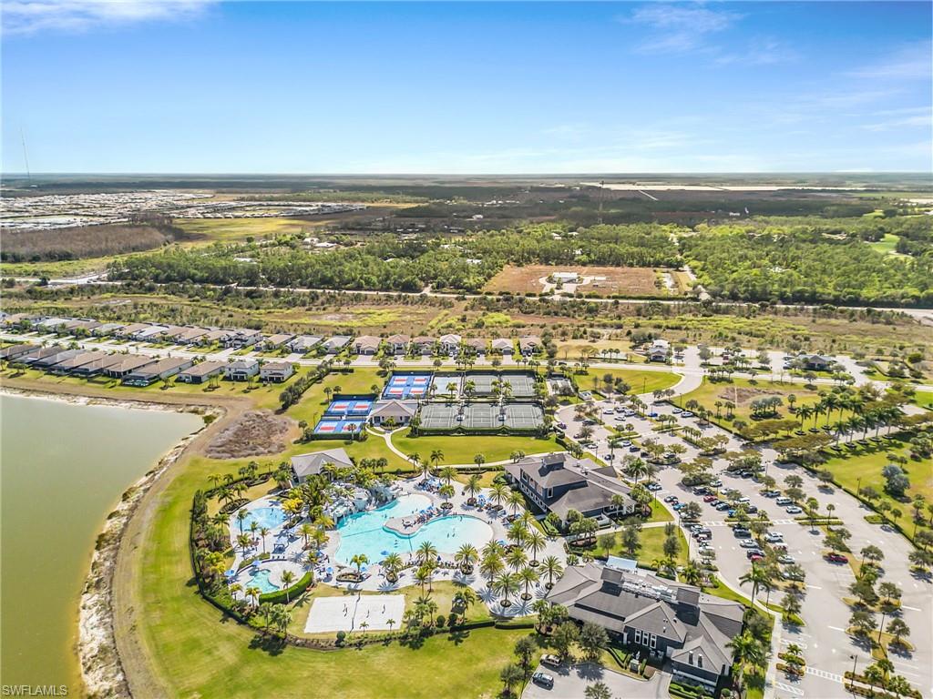 Aerial perspective of suburban area with a large body of water and a pool