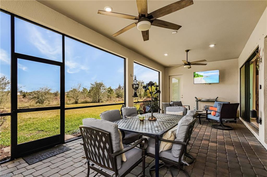 Sunroom / solarium with ceiling fan and outdoor dining space
