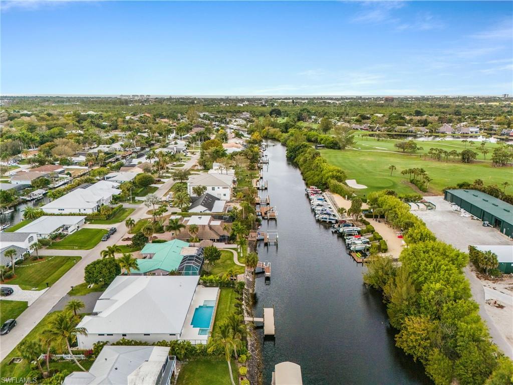 Aerial perspective of suburban area featuring a large body of water and a local golf course