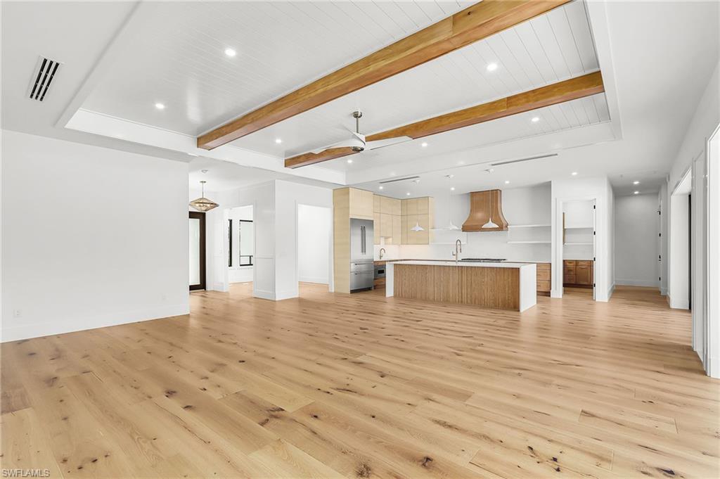 Unfurnished living room featuring recessed lighting, a ceiling fan, beamed ceiling, and light wood-style flooring