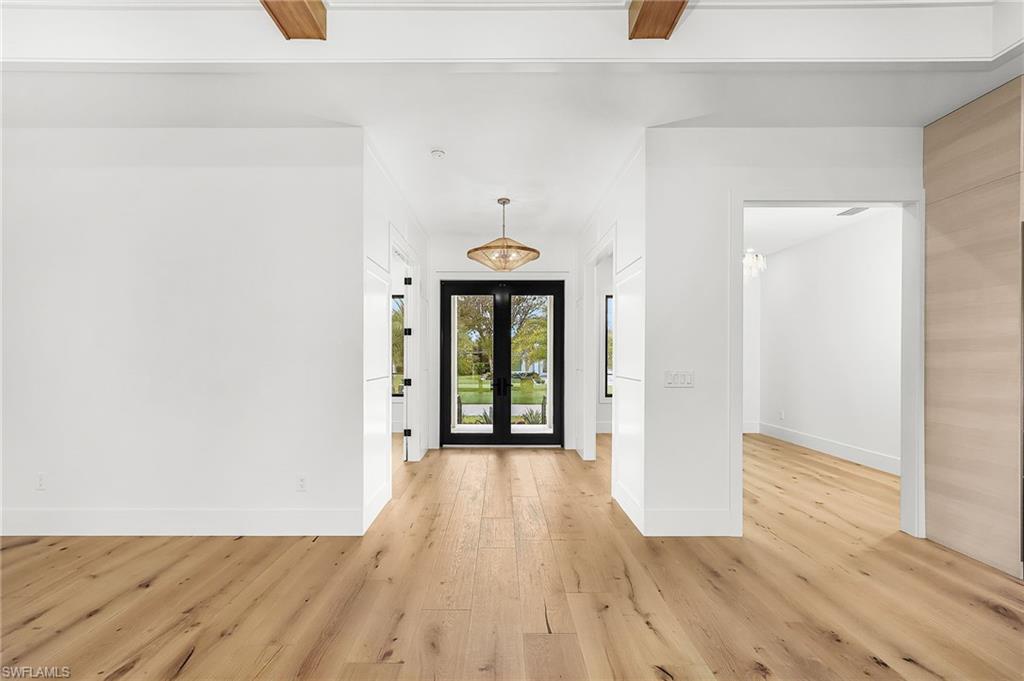 Foyer with light wood-style floors and french doors