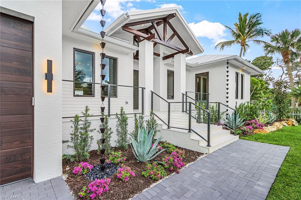 View of exterior entry featuring stucco siding and a metal roof