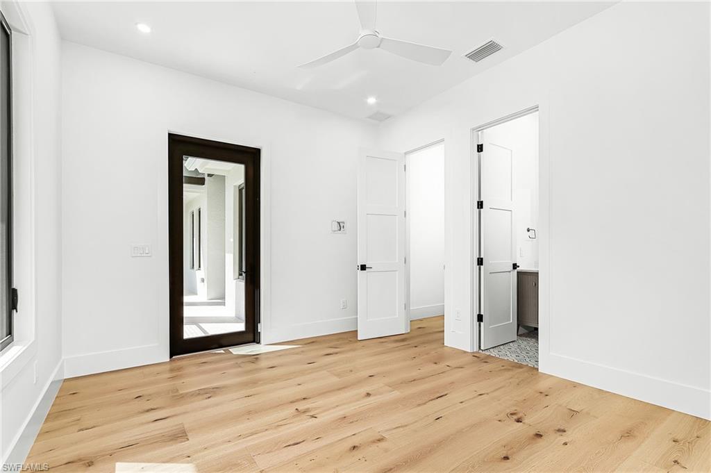 Unfurnished bedroom featuring light wood-type flooring, a ceiling fan, connected bathroom, and recessed lighting