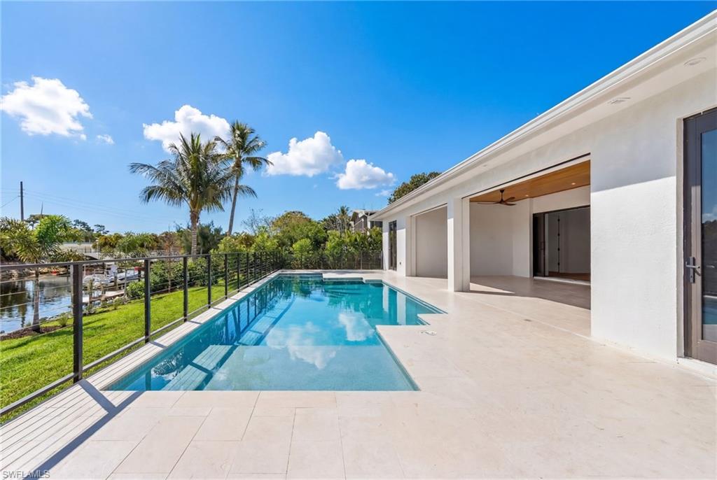 View of pool with patio surround and a water view