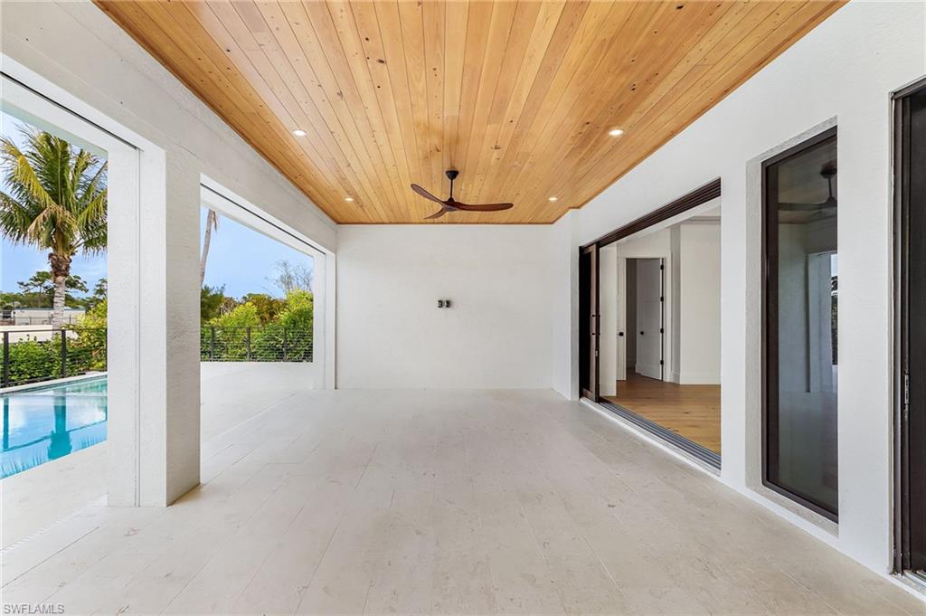 View of patio with a ceiling fan and an outdoor pool