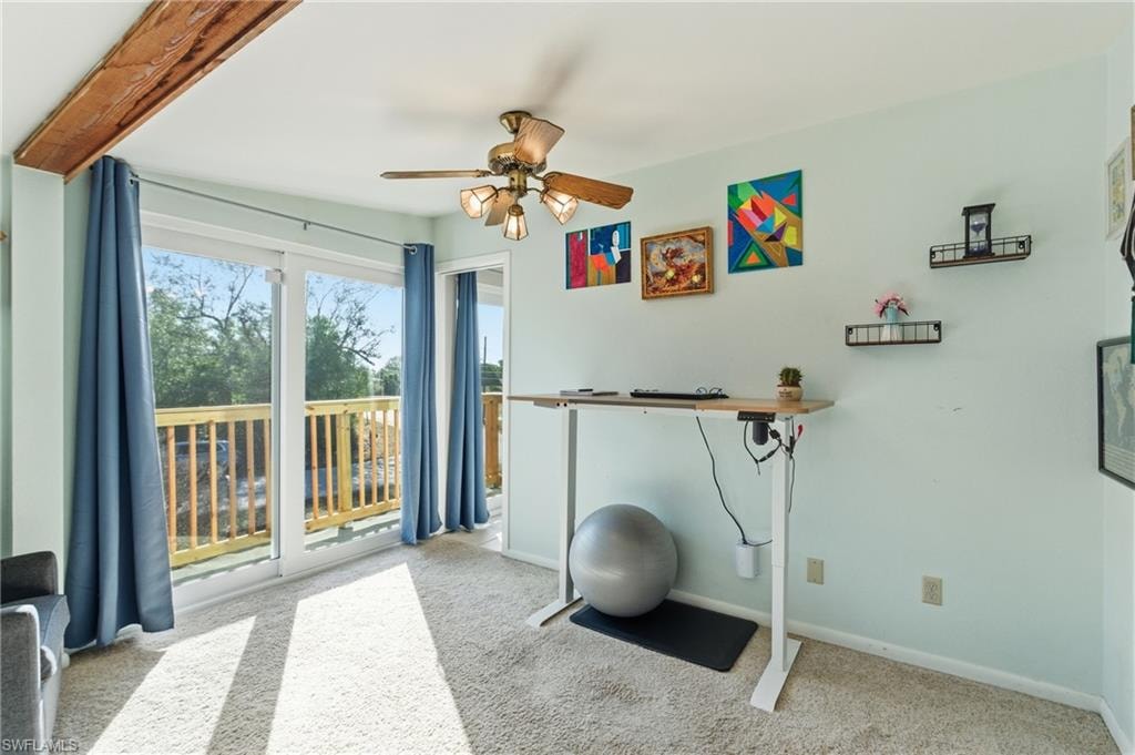 Office featuring beam ceiling, light colored carpet, and a ceiling fan