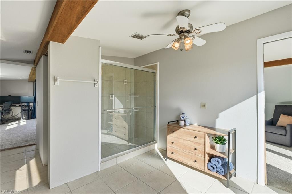 Half bathroom featuring vanity, light tile patterned flooring, light colored carpet, tile walls, and a closet