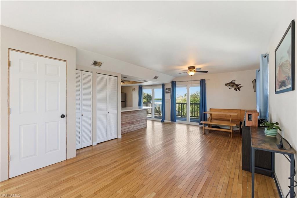 Kitchen with a ceiling fan, open floor plan, light countertops, stainless steel appliances, and a raised ceiling