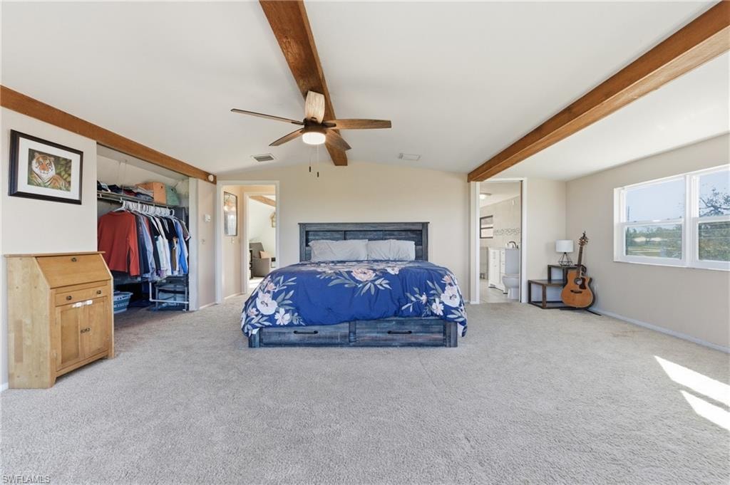 Bedroom with an office area, carpet, access to outside, lofted ceiling with beams, and a ceiling fan
