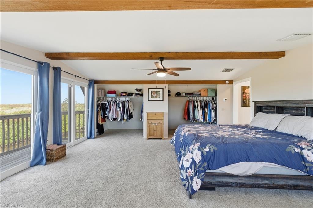 Bedroom with vaulted ceiling with beams, carpet, a ceiling fan, and ensuite bath