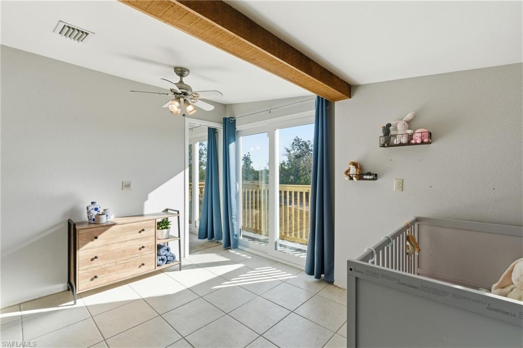 Living area featuring lofted ceiling with beams, carpet floors, and a ceiling fan