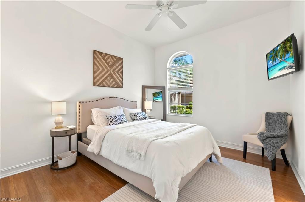 Bedroom with a ceiling fan, baseboards, and wood finished floors