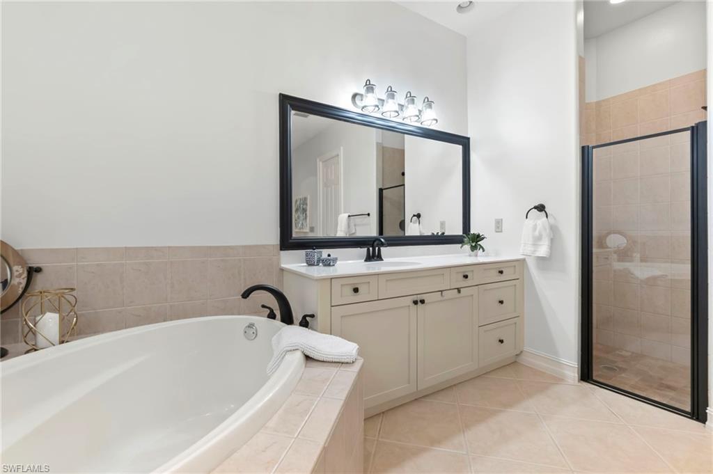 Full bathroom with a stall shower, vanity, a bath, and tile patterned floors