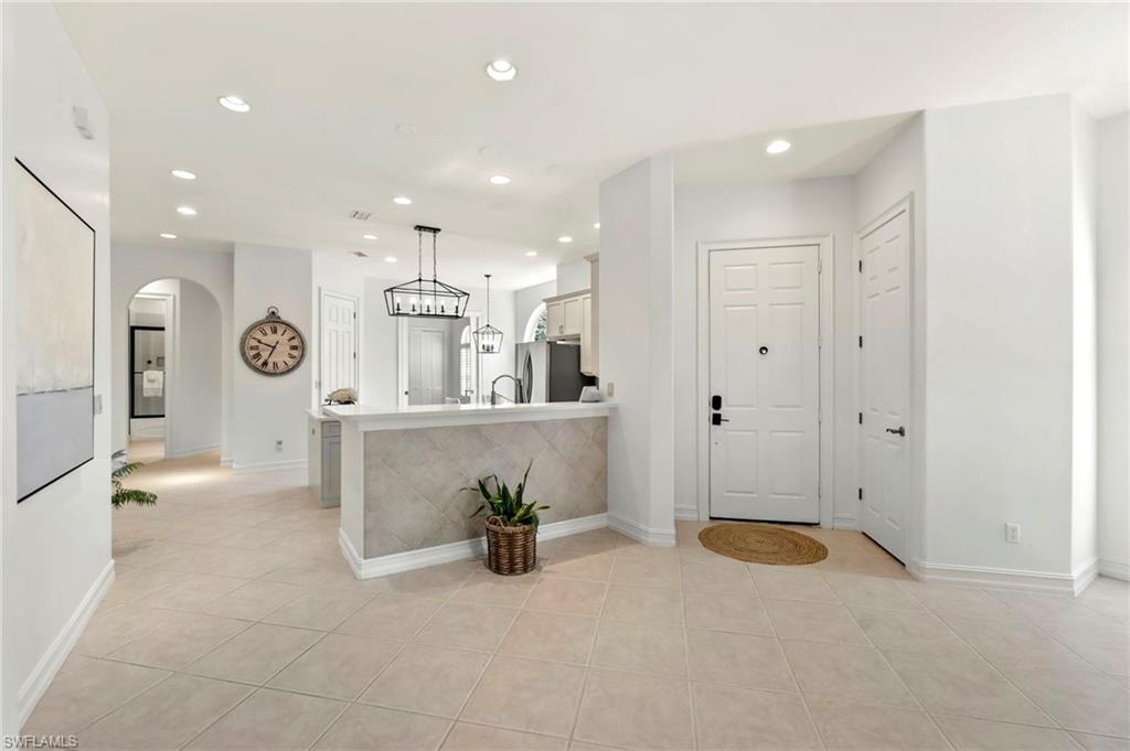 Entryway with recessed lighting, arched walkways, baseboards, and light tile patterned floors
