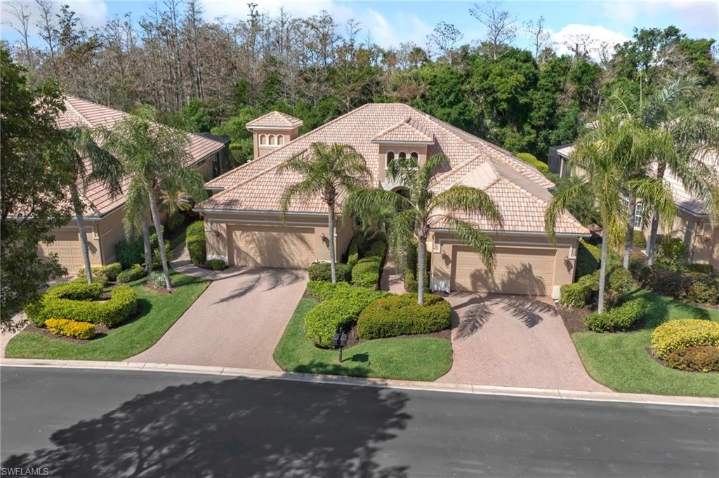 Mediterranean / spanish-style house with driveway, a tiled roof, an attached garage, and stucco siding