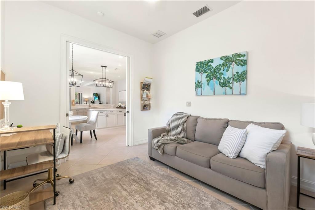 Living area featuring light tile patterned flooring and visible vents